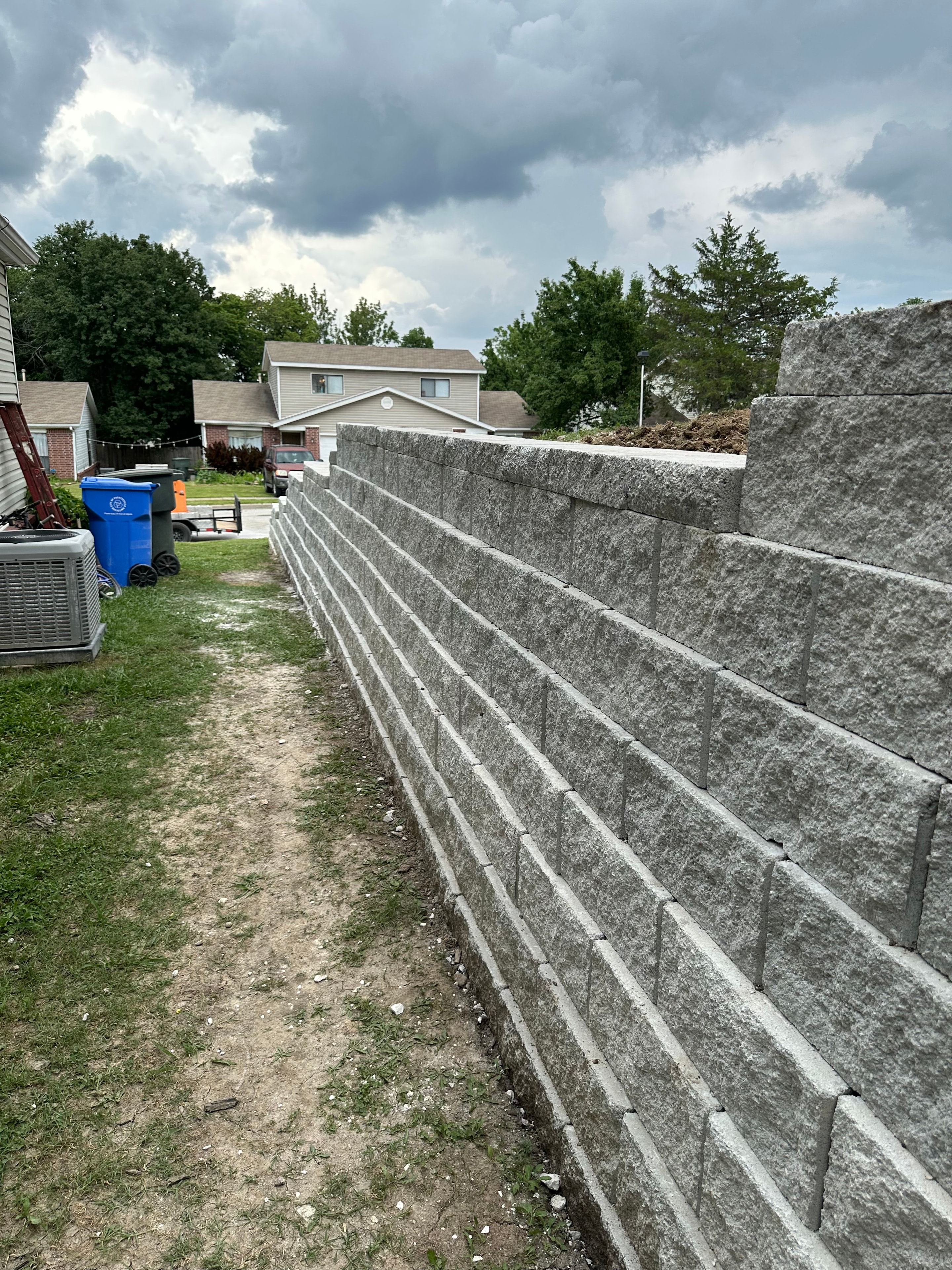 Tall block retaining wall on sloped yard